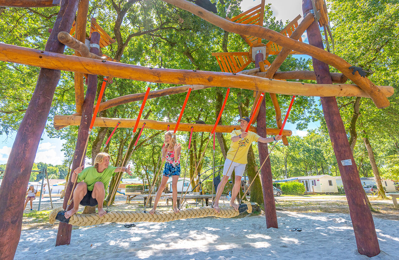 Wooden playground with braided swing at VAGUES OCEANES Domaine les Charmilles campsite in Saint-Laurent-de-la-Pr�e (17).