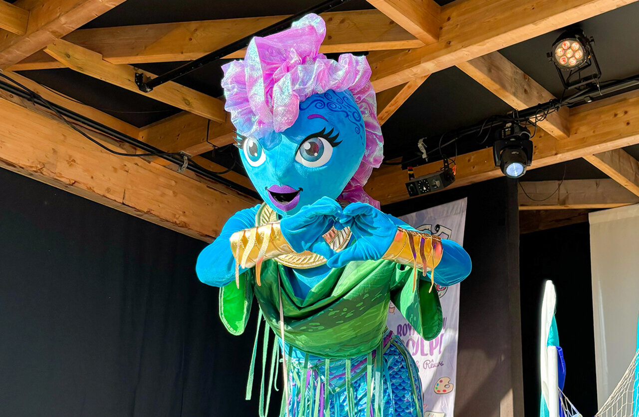 Blue mascot animating children's show at VAGUES OCEANES Domaine les Charmilles campsite.