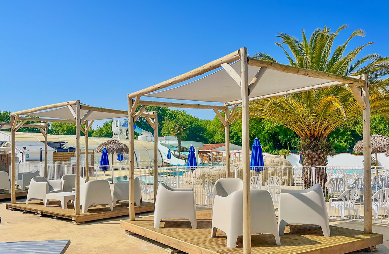 Shaded relaxation area, pool, water slides at VAGUES OCEANES Domaine les Charmilles campsite in Saint-Laurent-de-la-Pr�e (17).