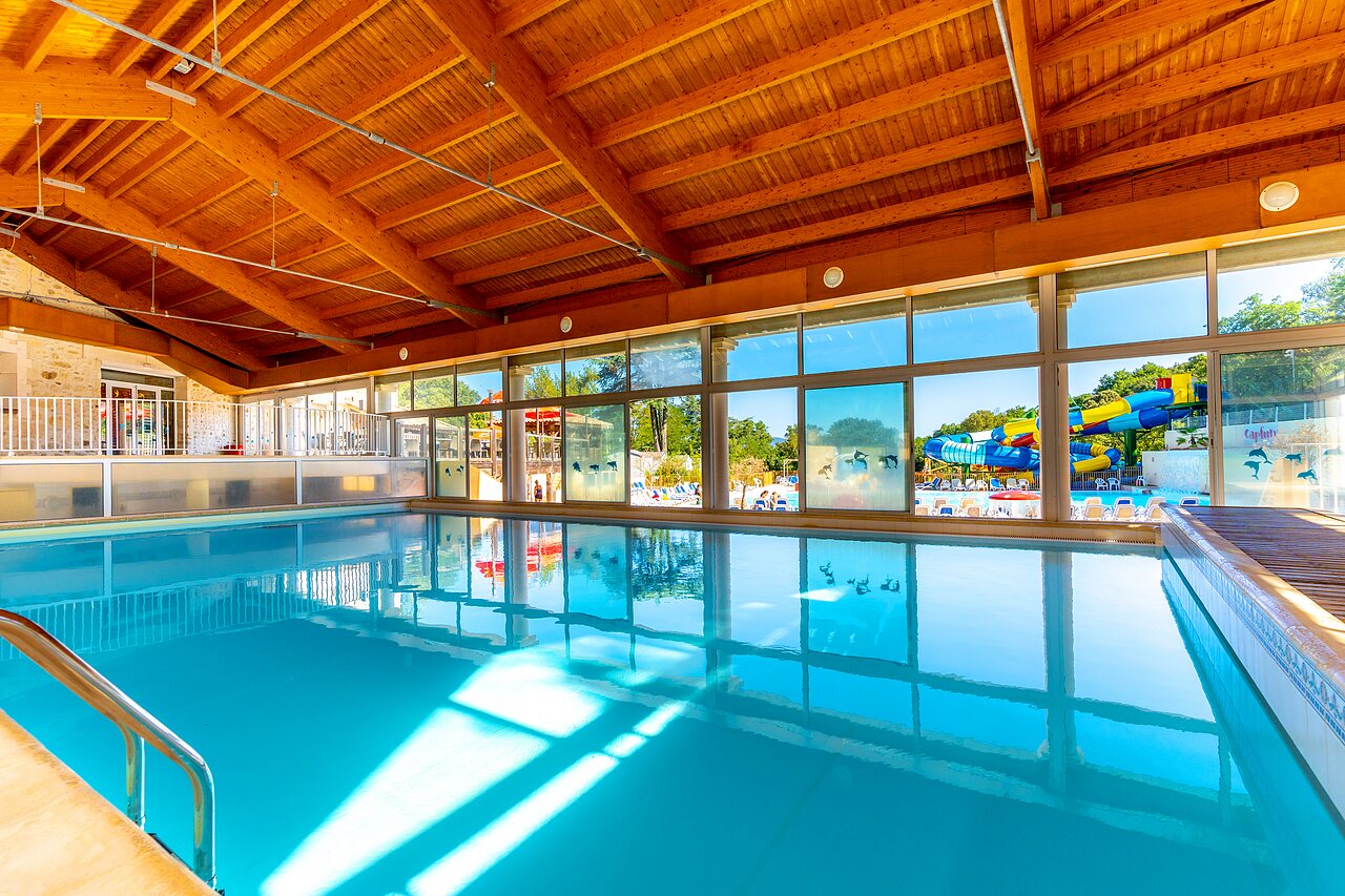 Indoor pool, slides at CLICOCHIC Ch�teau de Boisson campsite in All�gre-les-Fumades.