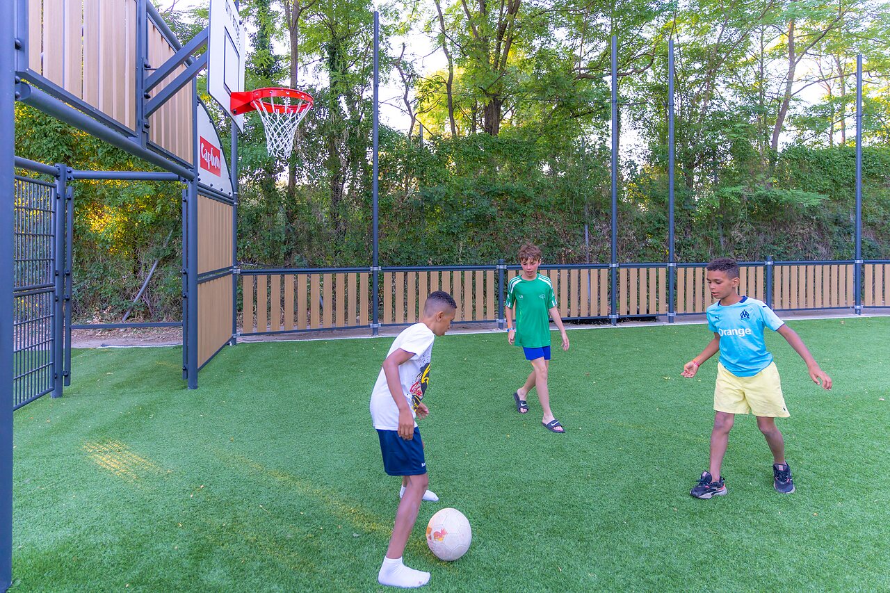Multi-sport field children playing at camping CLICOCHIC Ch�teau de Boisson All�gre-les-Fumades.