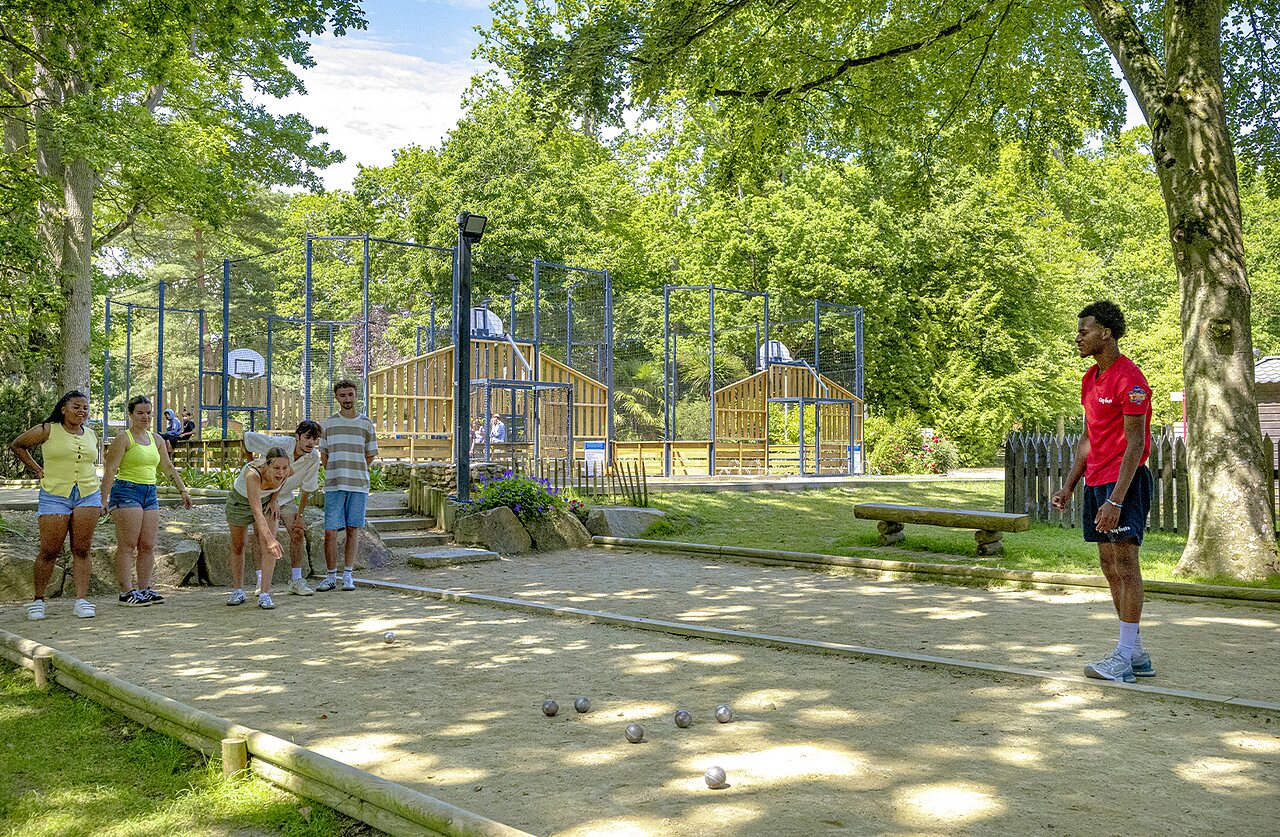 Young people playing p�tanque, multi-sport court in background at CAPFUN Ch�teau de Galin�e campsite in SAINT CAST LE GUILDO (22).