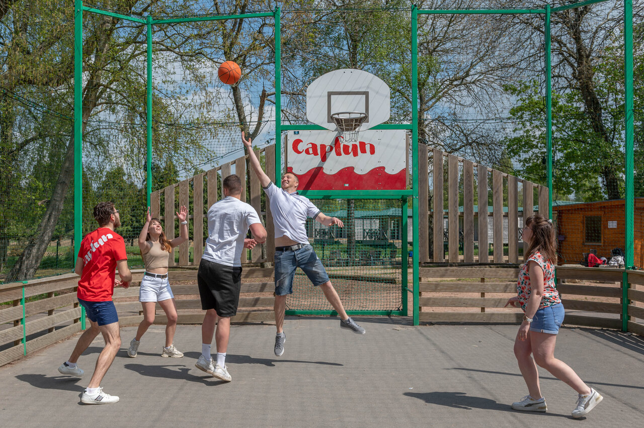 Basketball game on multisport court at CAPFUN Chateau d'Arvid campsite in Villerville.