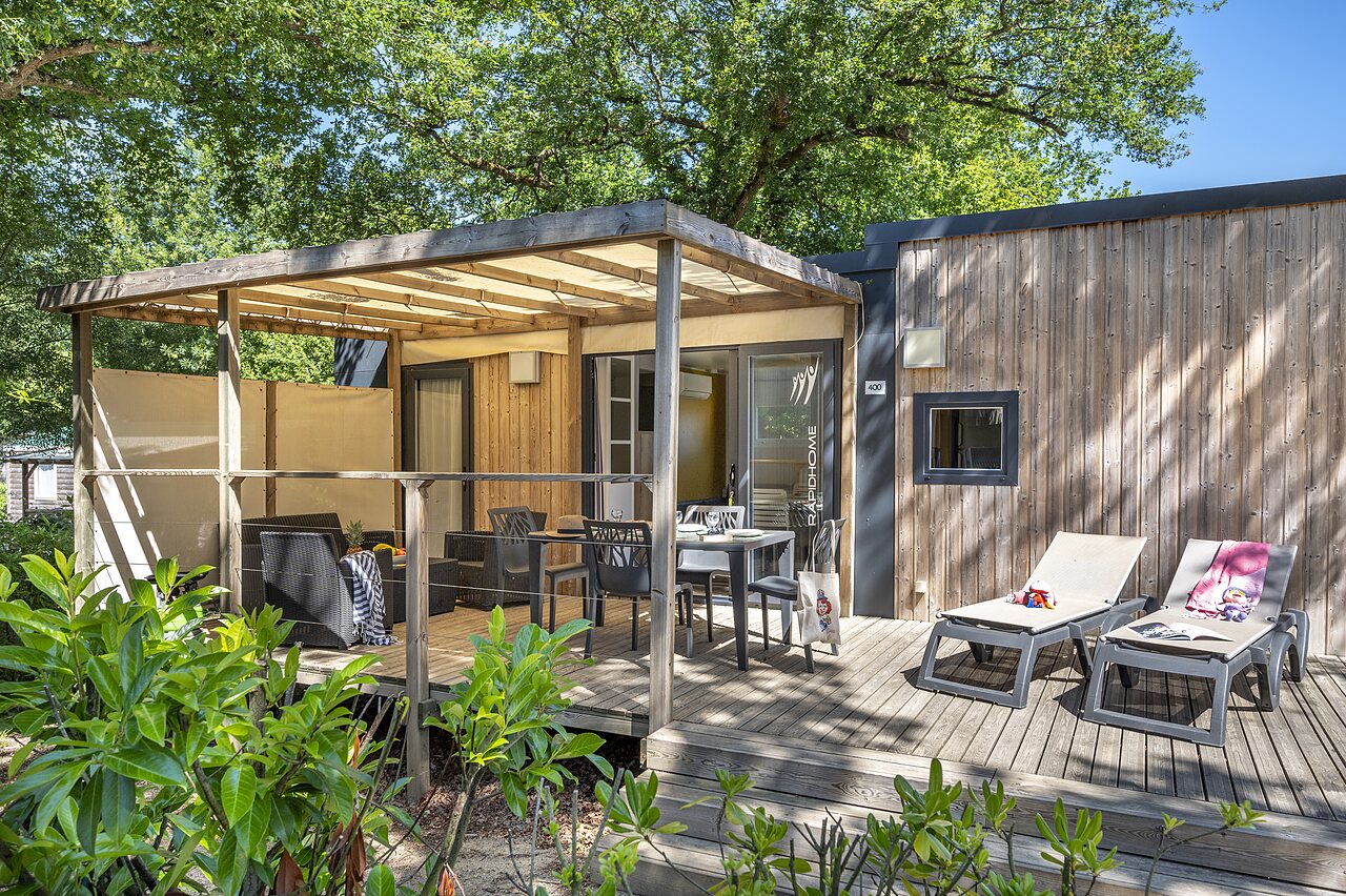Modern mobile home with furnished terrace and sun loungers at CAPFUN La Ch�naie campsite in PORNIC (44).