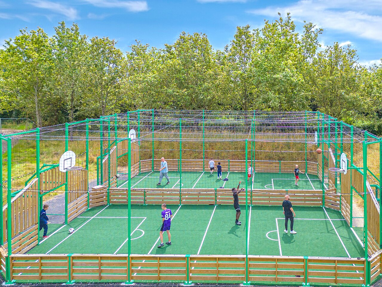 Outdoor multi-sport court with players at CAPFUN La Ch�naie campsite in PORNIC (44).