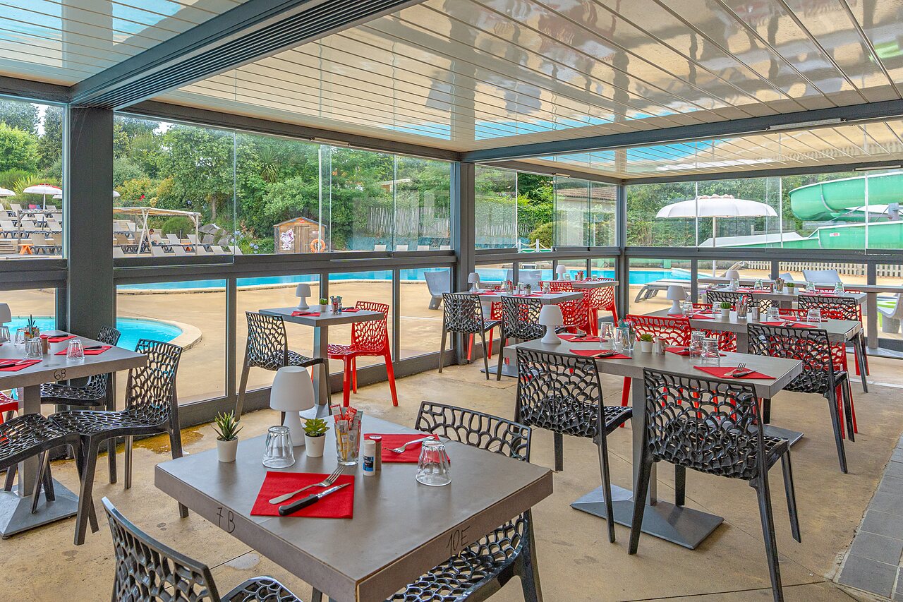 Modern restaurant overlooking swimming pool and waterslide at CAPFUN La Ch�naie in PORNIC (44).
