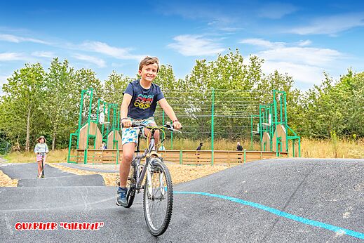 Pump track and child on bike at CAPFUN La Ch�naie campsite, PORNIC (44).