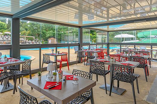 Modern restaurant with tables and chairs by the pool at CAPFUN La Ch�naie campsite in PORNIC (44).