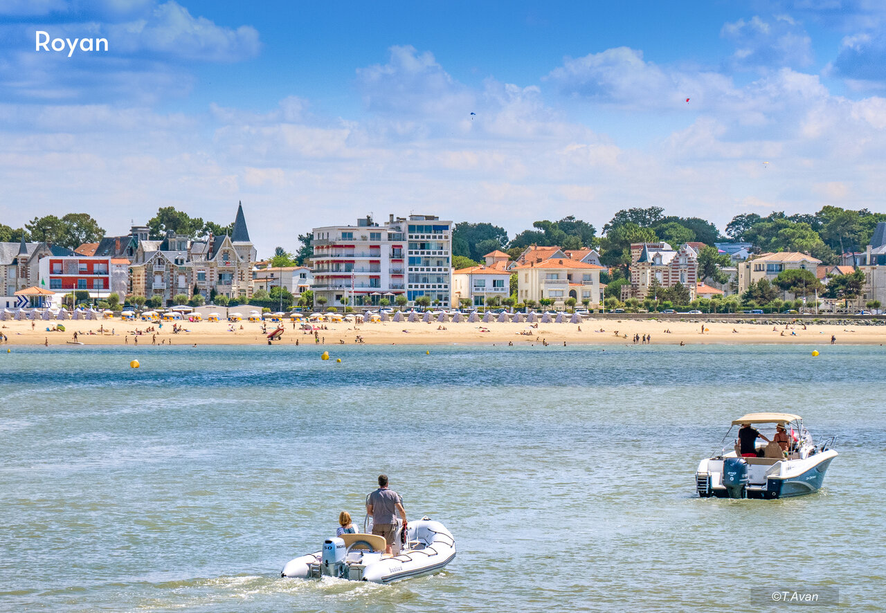 Royan beach with swimmers, boats, and coastal architecture in Charente-Maritime.