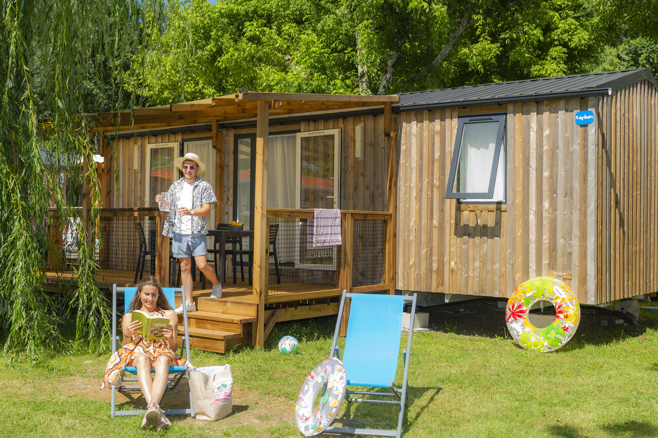 Modern mobile home with terrace, couple relaxing at CAPFUN Ch�nes campsite in Medis/Royan (17).
