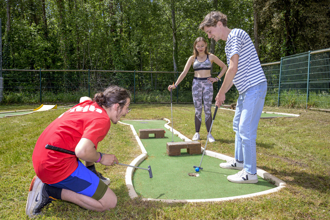 Young people enjoying mini-golf at CAPFUN Ch�nes campsite in Medis/Royan.