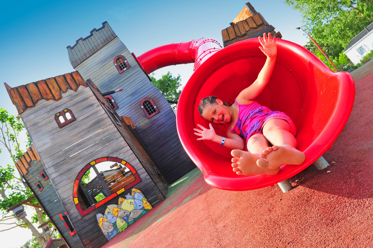 Red slide and smiling child. Playground CAPFUN Ch�nes in Medis/Royan.