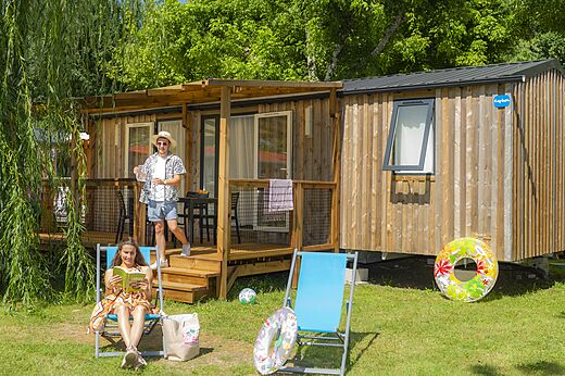 Wooden mobile home with terrace, couple on holiday at CAPFUN Ch�nes campsite in Medis/Royan (17).