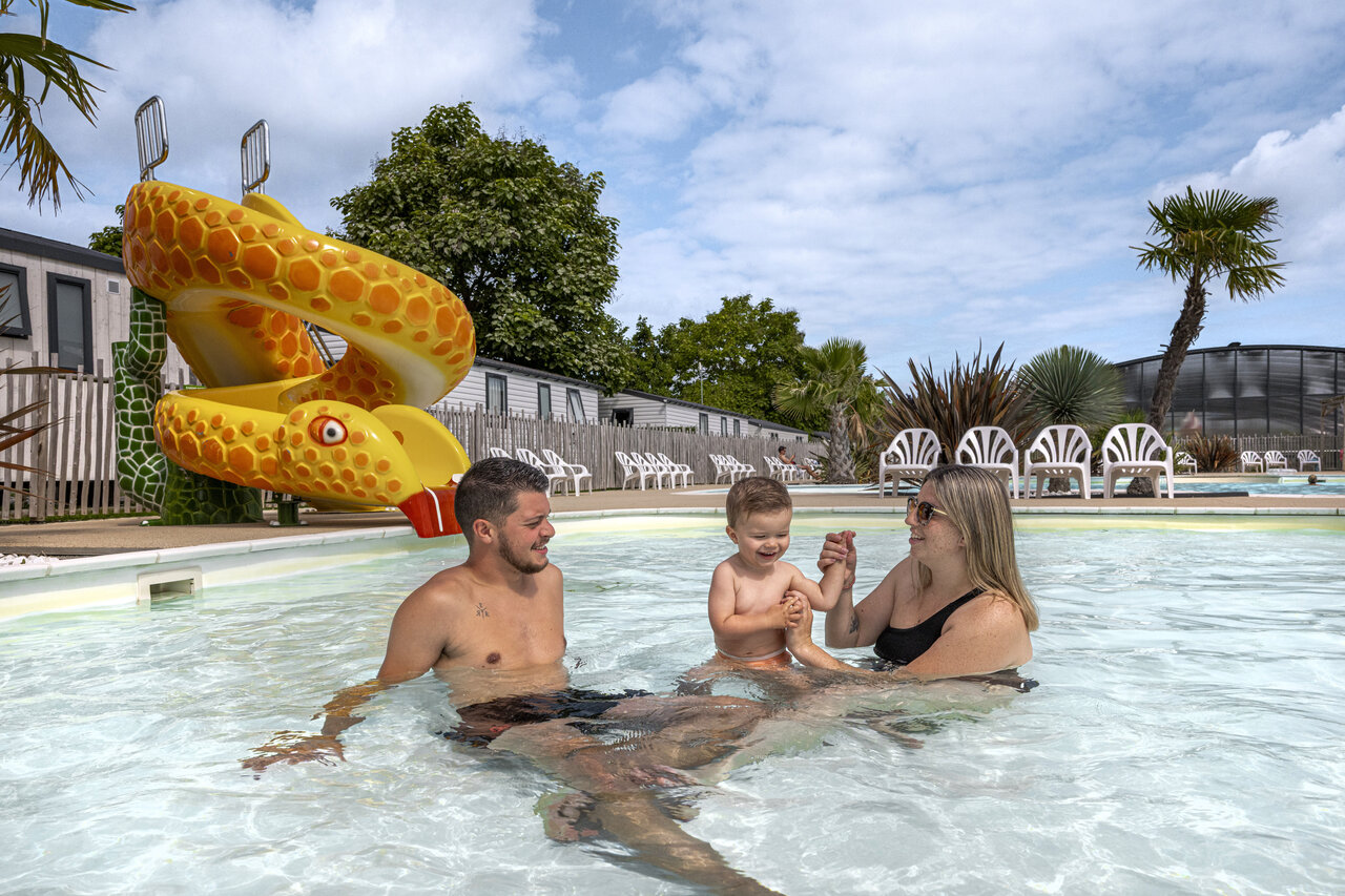Family with child enjoying pool and snake slide at campsite CLICOCHIC Chevaliers in HOULGATE (14).