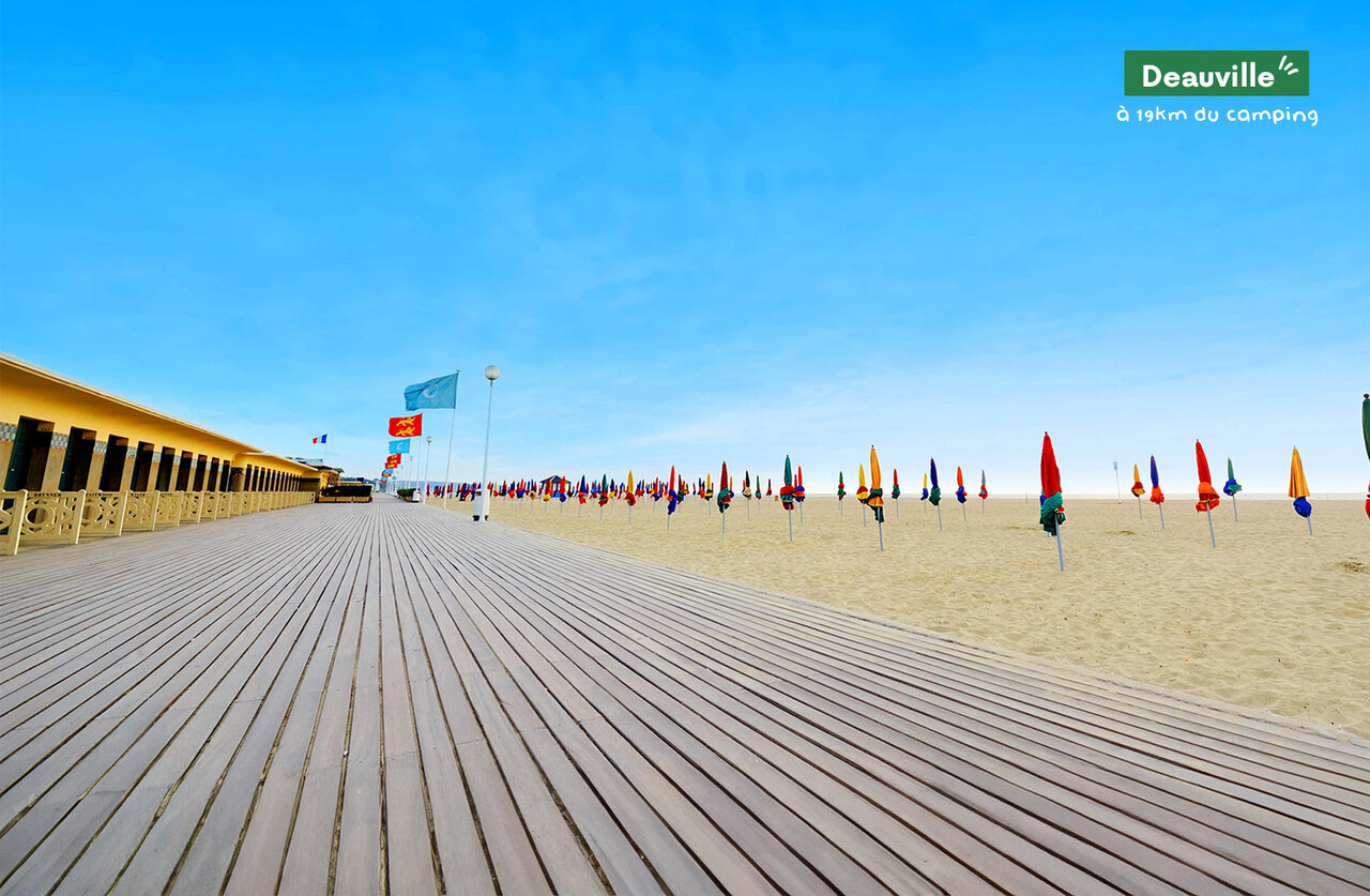Famous Deauville boardwalk, beach cabins, and colorful parasols in Normandy.