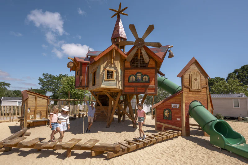 Wooden playground with slides at CLICOCHIC Chouans campsite (85).