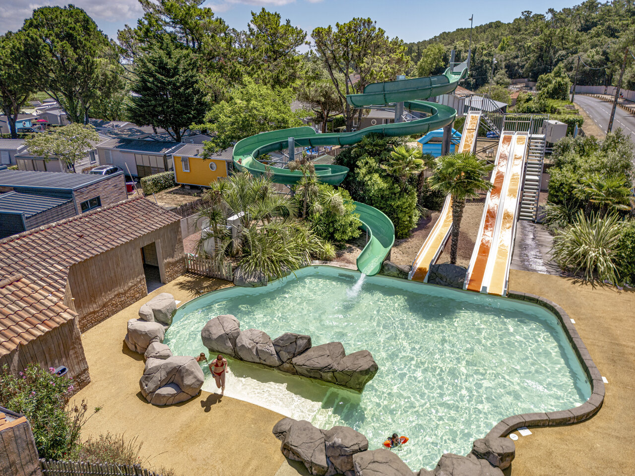 Outdoor pool, water slides, mobile homes at CLICOCHIC Chouans campsite (85).
