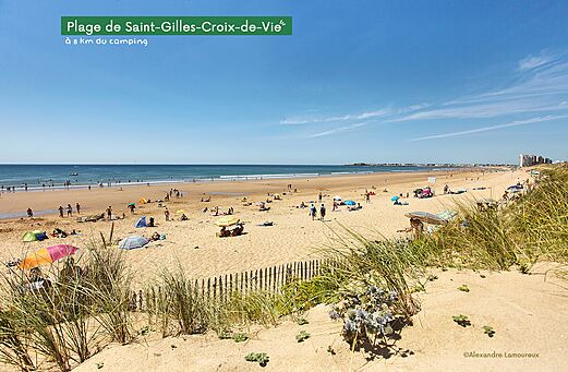 Wide sandy beach in Saint-Gilles-Croix-de-Vie, Vend�e, with swimmers and parasols.