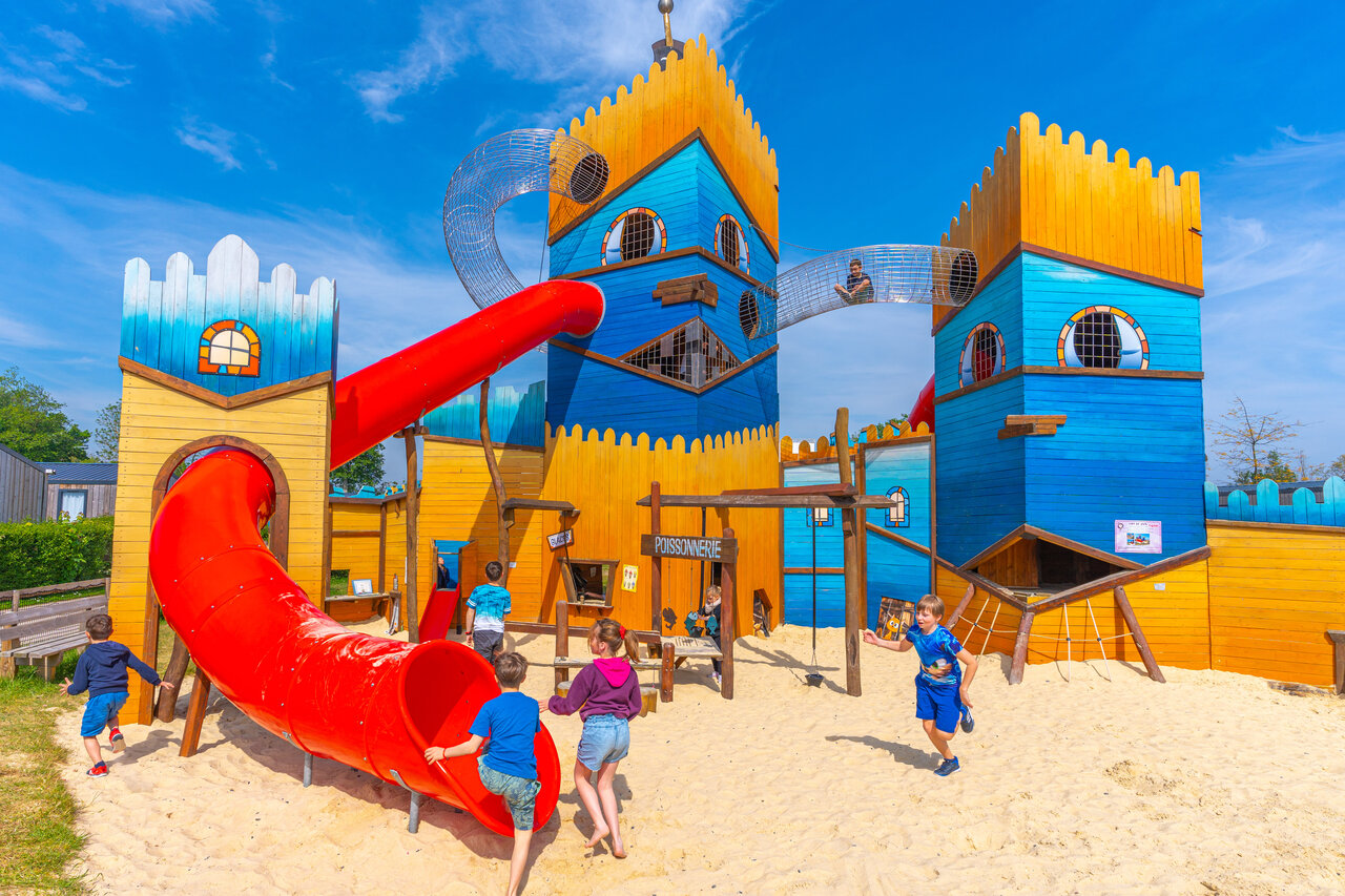 Castle playground, slide, children at CAPFUN Citadelle de Loustic campsite.