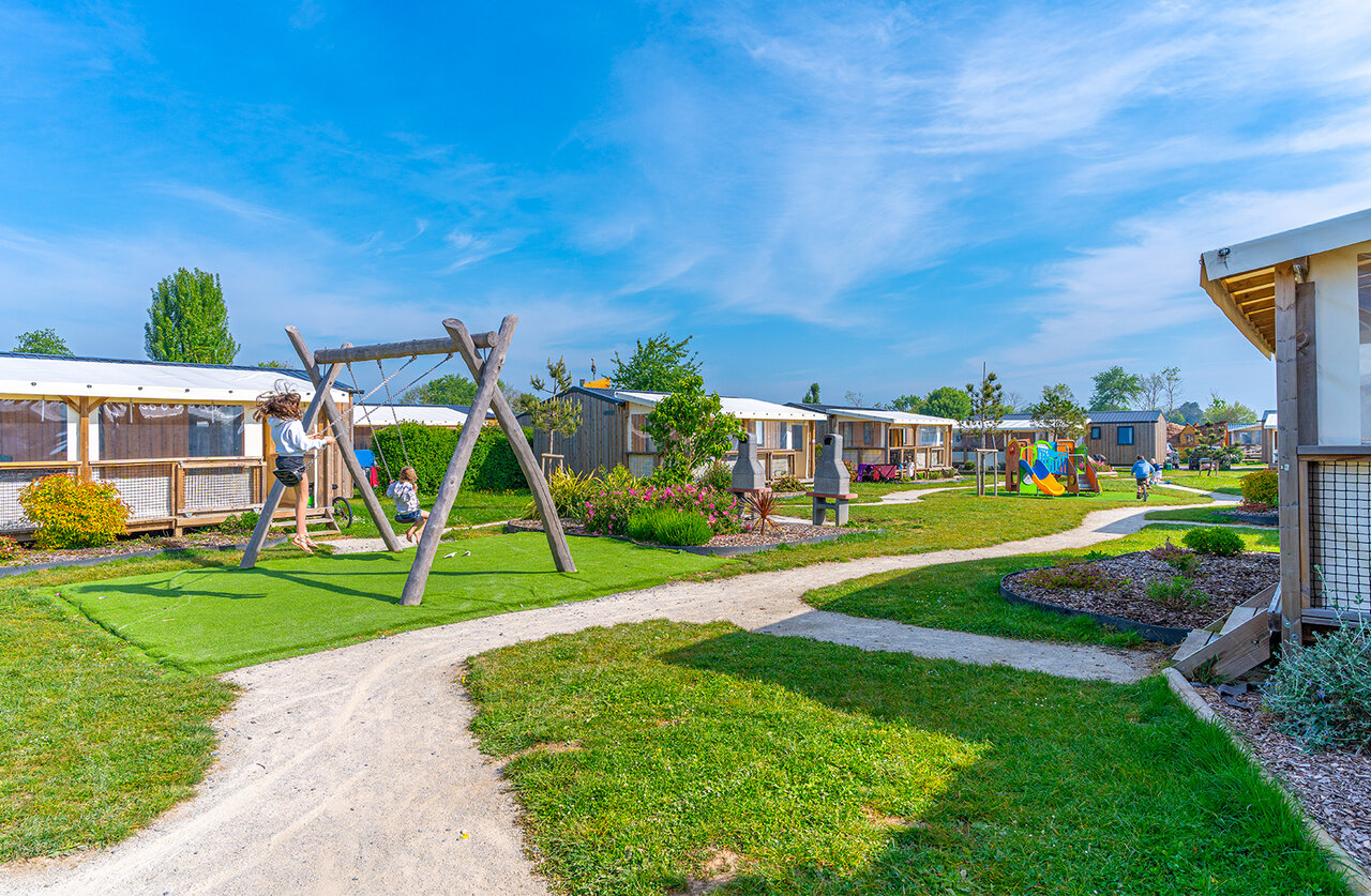 Wooden swings and children's playground at CAPFUN Citadelle de Loustic campsite in Hermanville sur Mer (14).