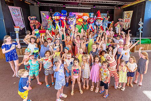 Children and mascots on stage during an animation at CAPFUN Citadelle de Loustic campsite in Hermanville sur Mer.