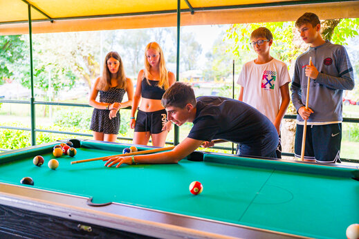 Teenagers playing billiards at CAPFUN Citta di Angera campsite in Angera VA.