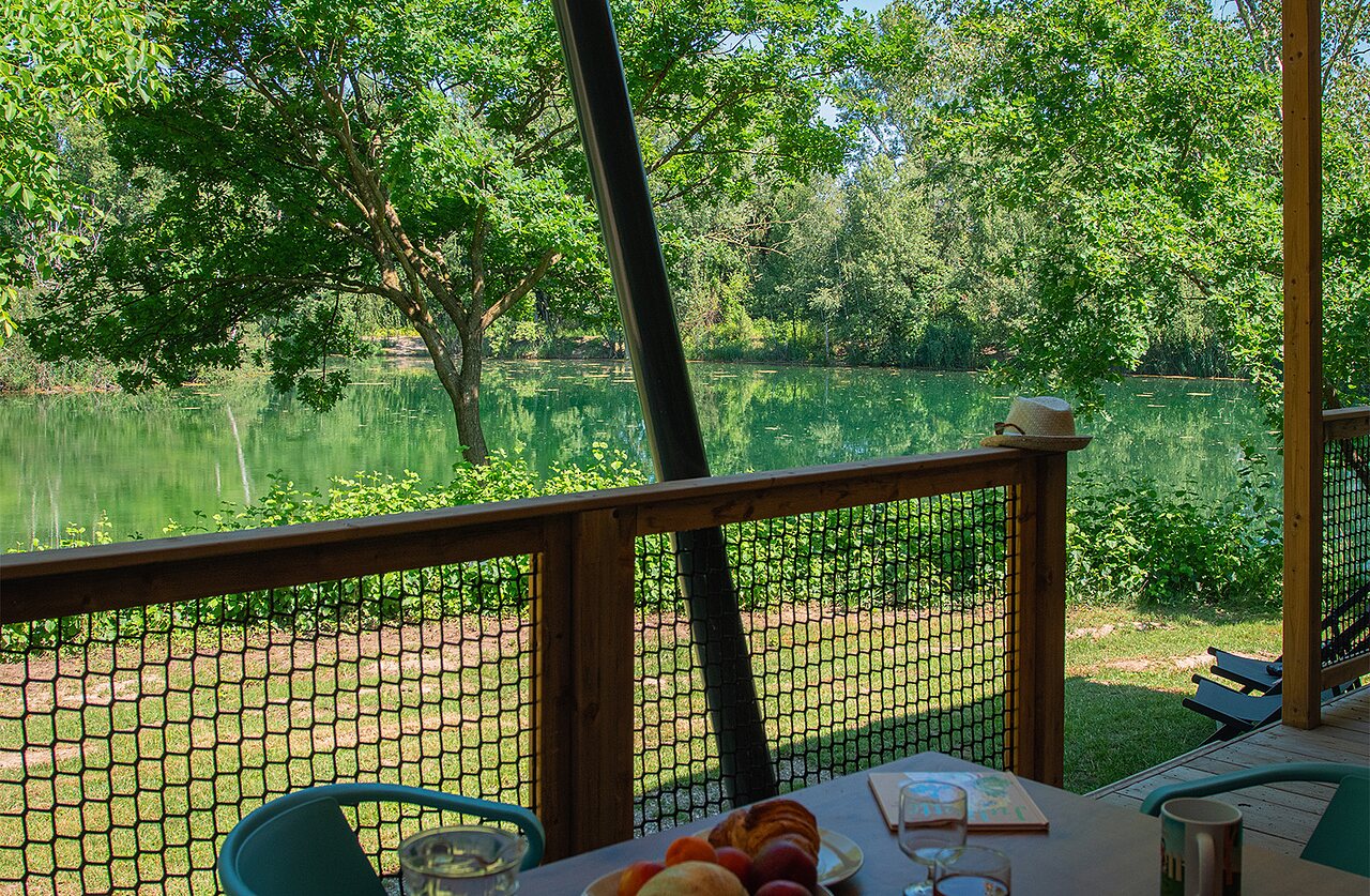 Accommodation terrace with lake view at CLICOCHIC Au Clair Ruisseau campsite in Gerstheim.