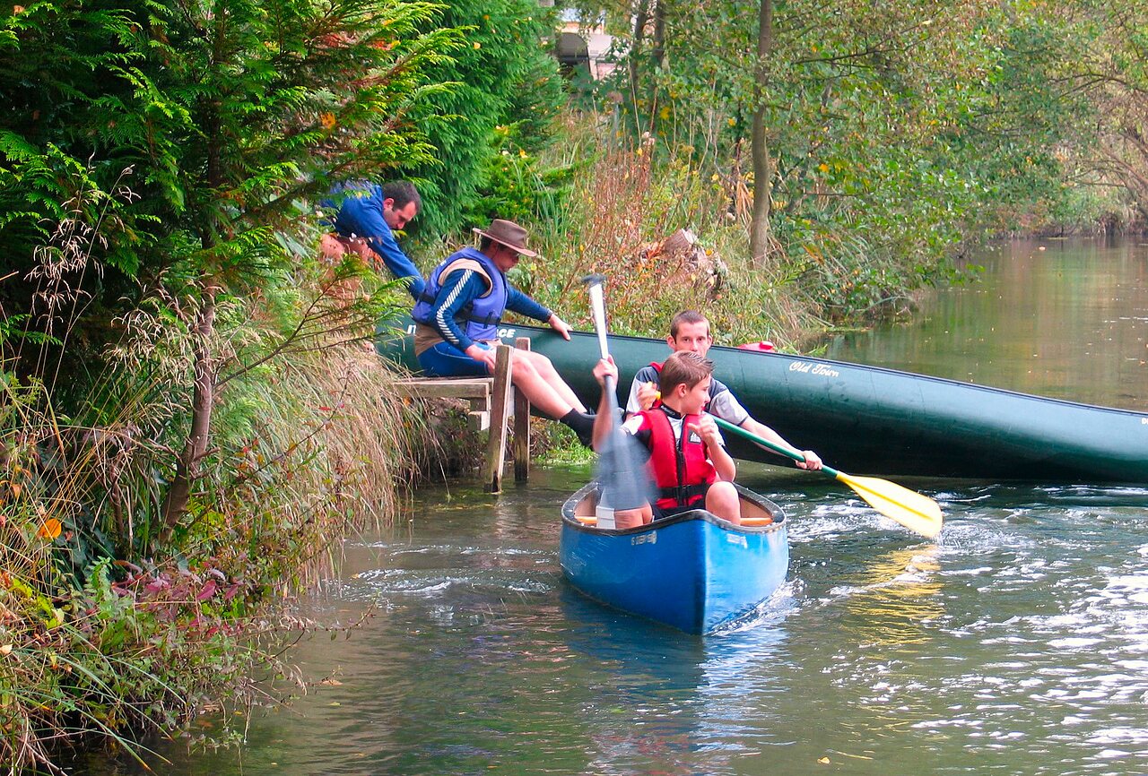Family canoeing on the river at CLICOCHIC Au Clair Ruisseau campsite in Gerstheim (67).