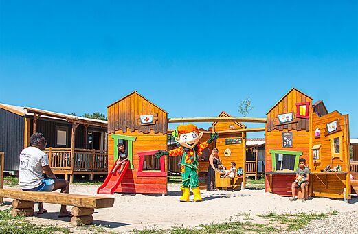 Wooden playground, slide, mascot at CLICOCHIC Au Clair Ruisseau campsite.