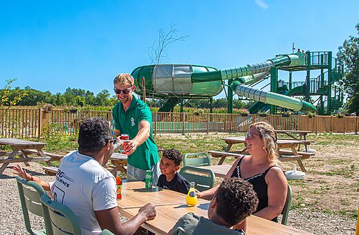 Family at bar on terrace at camping CLICOCHIC Au Clair Ruisseau.