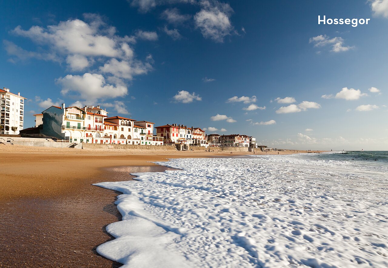 Hossegor beach with waves and colorful buildings, a place to visit near the campsite.