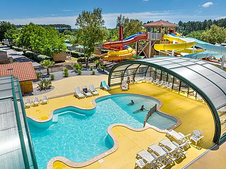 Covered swimming pool and colorful water slides at CAPFUN Clown Océan campsite in TOSSE (40).