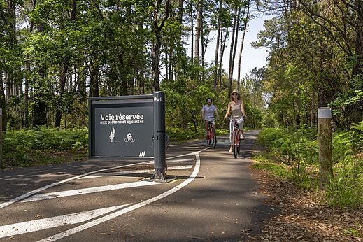 Forest cycling path with two people on bikes at CAPFUN Clown Océan campsite in TOSSE (40).