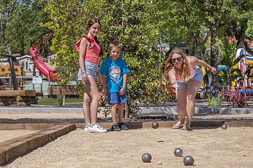 Family playing pétanque on the games court at CAPFUN Clown Océan campsite in TOSSE (40).