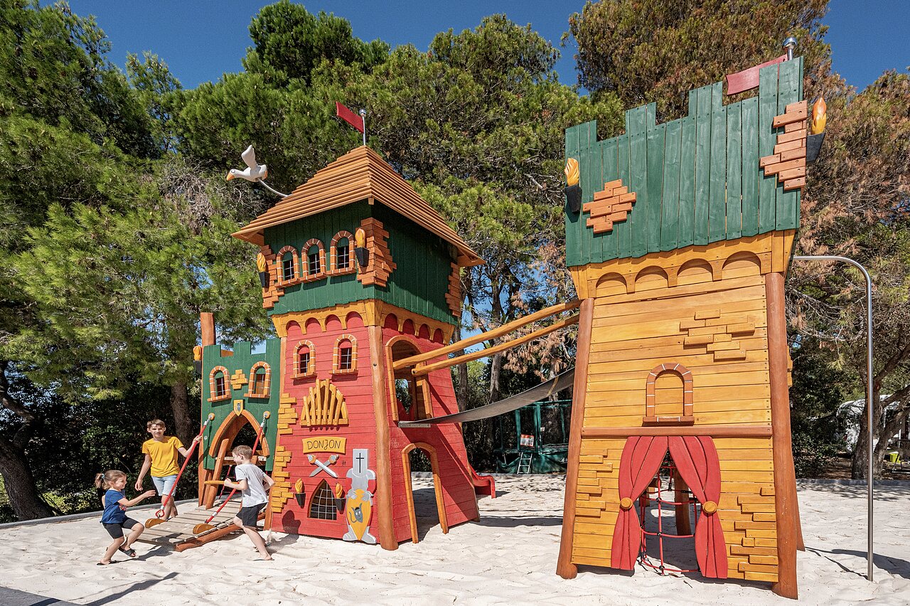 Kids' wooden play castle at CLICOCHIC Commanderie campsite in Rustiques (11).