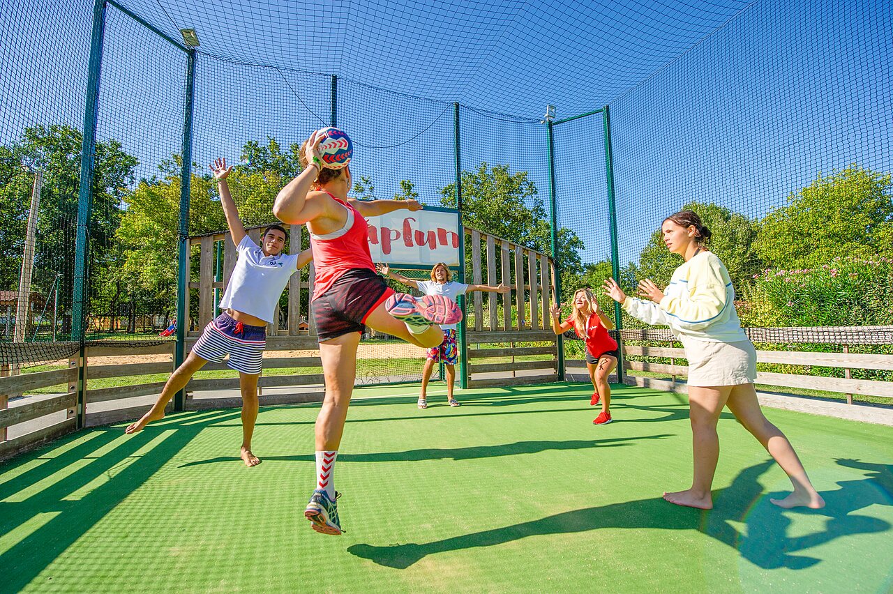 Young people playing volleyball on multisport court at CAPFUN Coquelicots campsite in Royan (17).
