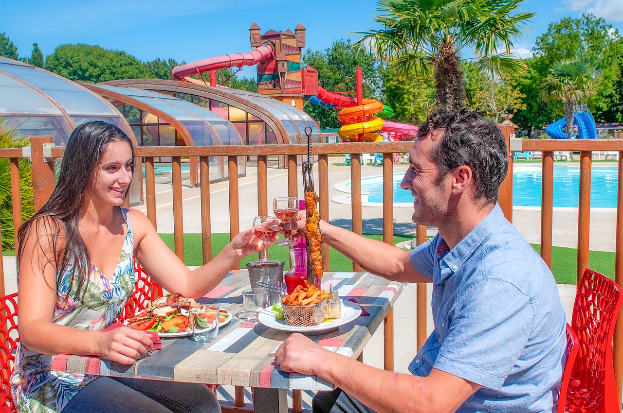 Couple dining, water park with slides, CAPFUN Coquelicots campsite Royan (17).