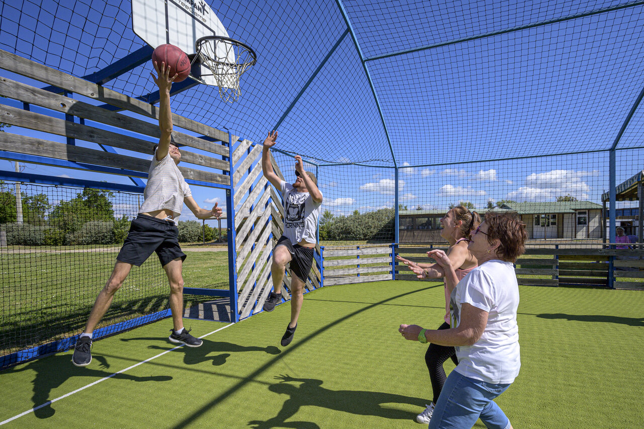 Multisport court with holidaymakers playing basketball at VAGUES OCEANES Coq Hardi campsite in Cassy-Lanton (33).
