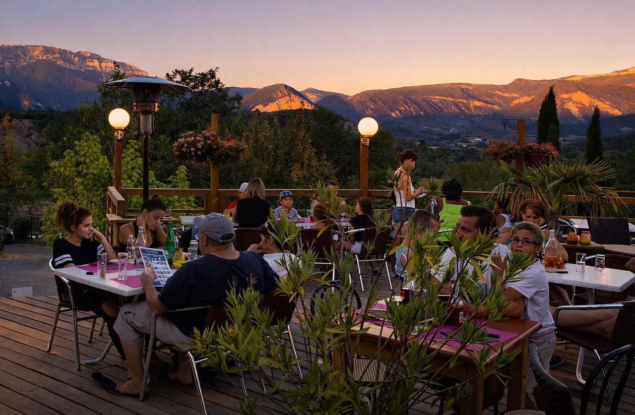 Dinner on terrace with panoramic mountain view at CLICOCHIC Couriou campsite.