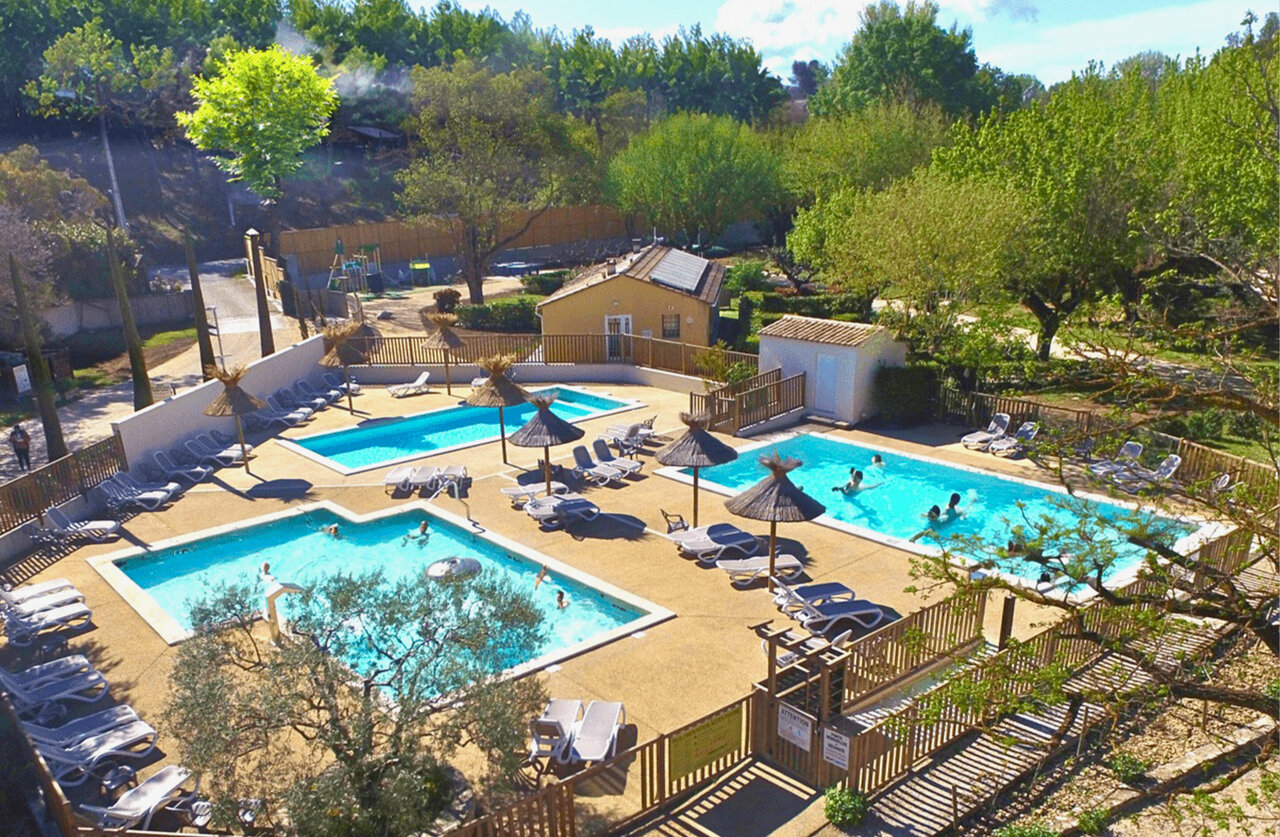 Aquatic complex with multiple pools, sun loungers and parasols at CLICOCHIC Couteli�re campsite in Lagnes (84).
