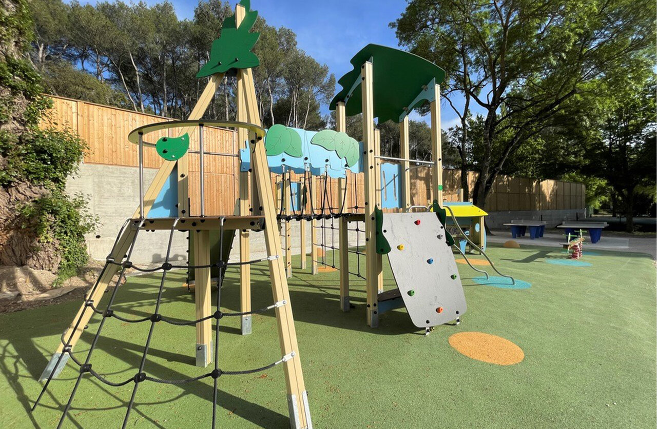 Modern playground with climbing wall, nets, slides at CLICOCHIC Couteli�re campsite in Lagnes (84).