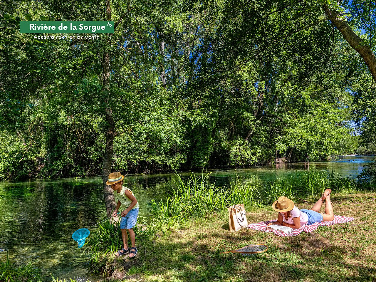 Direct access Sorgue River, child fishing, adult reading at CLICOCHIC campsite.