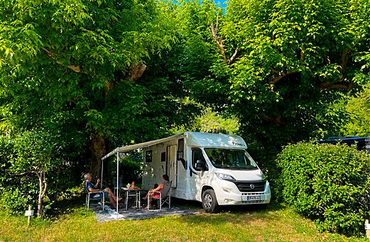 Motorhome on shaded pitch at CLICOCHIC Coutelière campsite in Lagnes (84).
