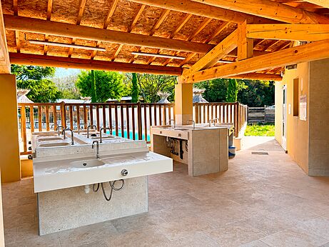 Covered dishwashing area with multiple sinks at CLICOCHIC Coutelière campsite in Lagnes (84).