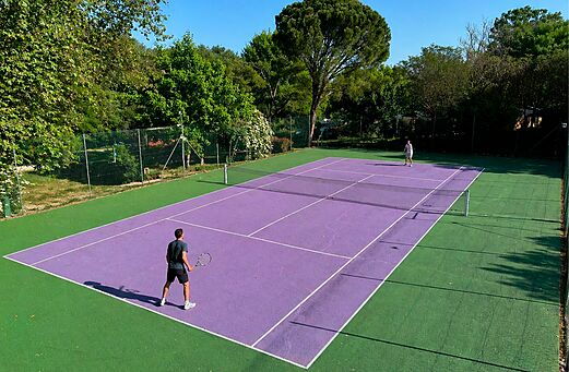 Purple tennis court with two players at CLICOCHIC Coutelière campsite in Lagnes (84).