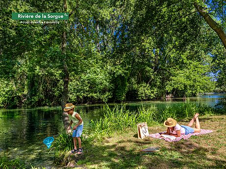 Direct access Sorgue River, child fishing, adult reading at CLICOCHIC campsite.