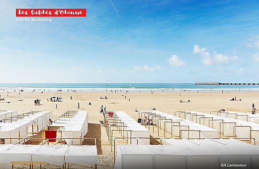 Wide sandy beach of Les Sables d'Olonne with beach huts.