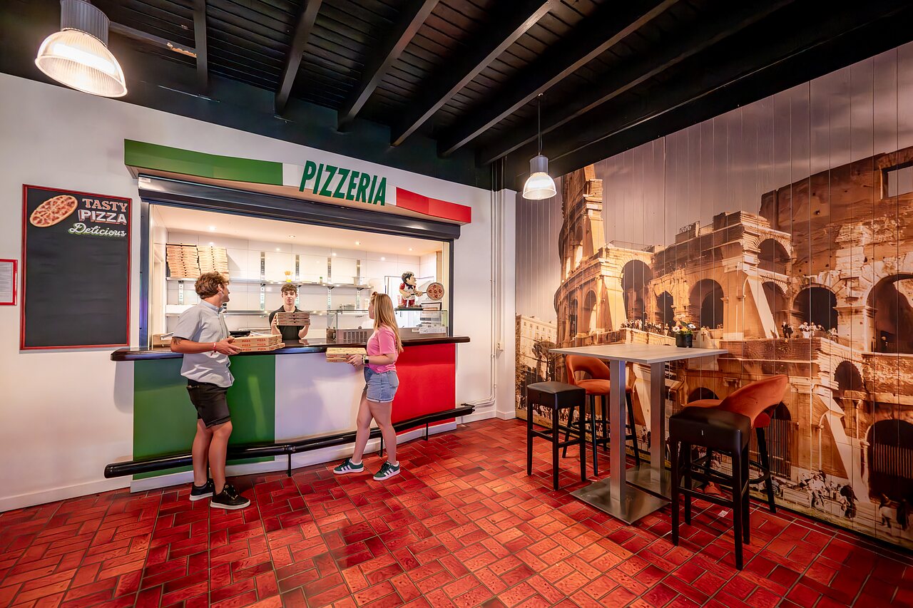 Modern pizzeria with customers and staff at CAPFUN De Belten campsite in Rheeze.