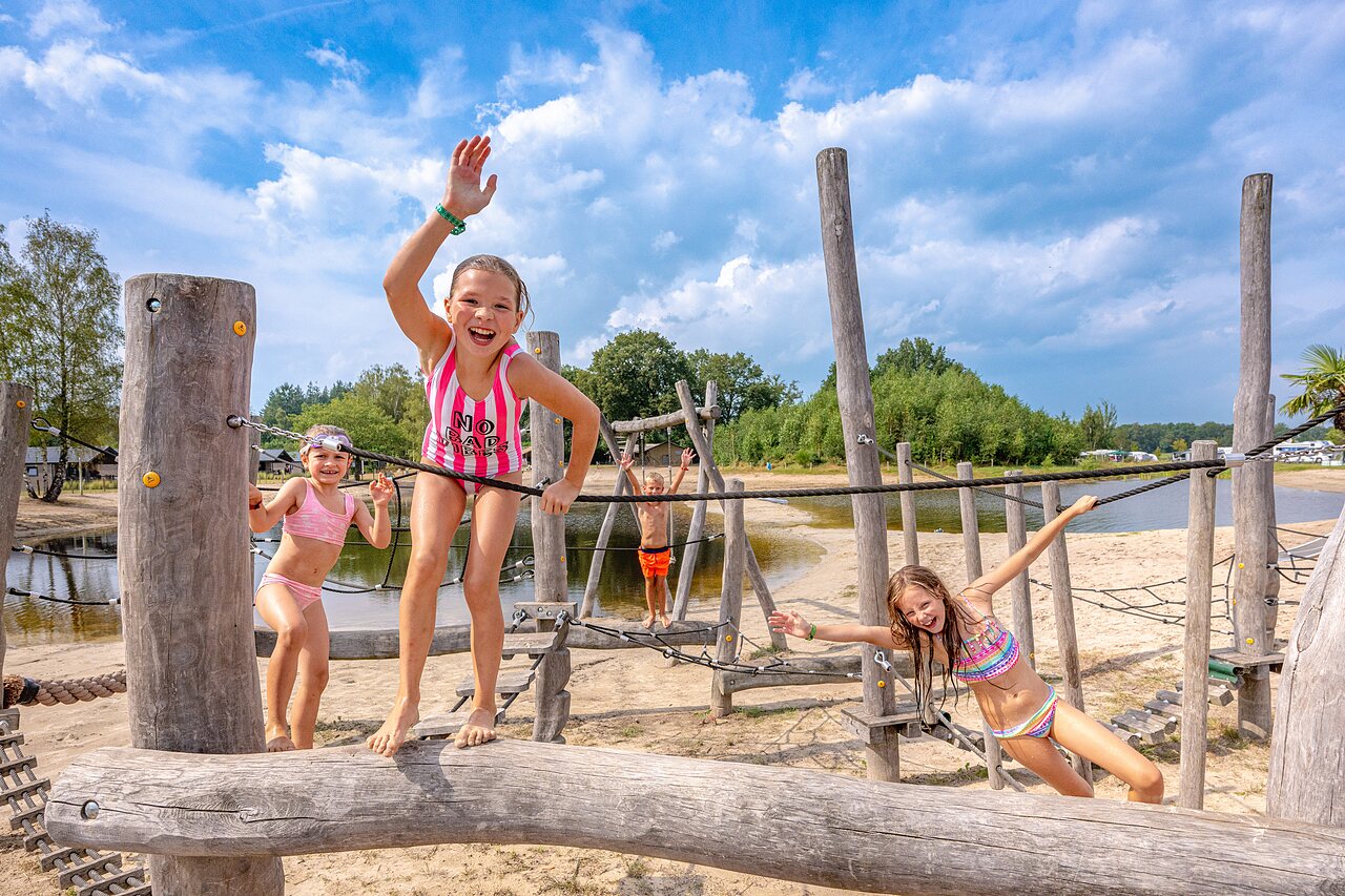 Children on wooden playground, sandy beach at CAPFUN De Belten campsite in Rheeze.