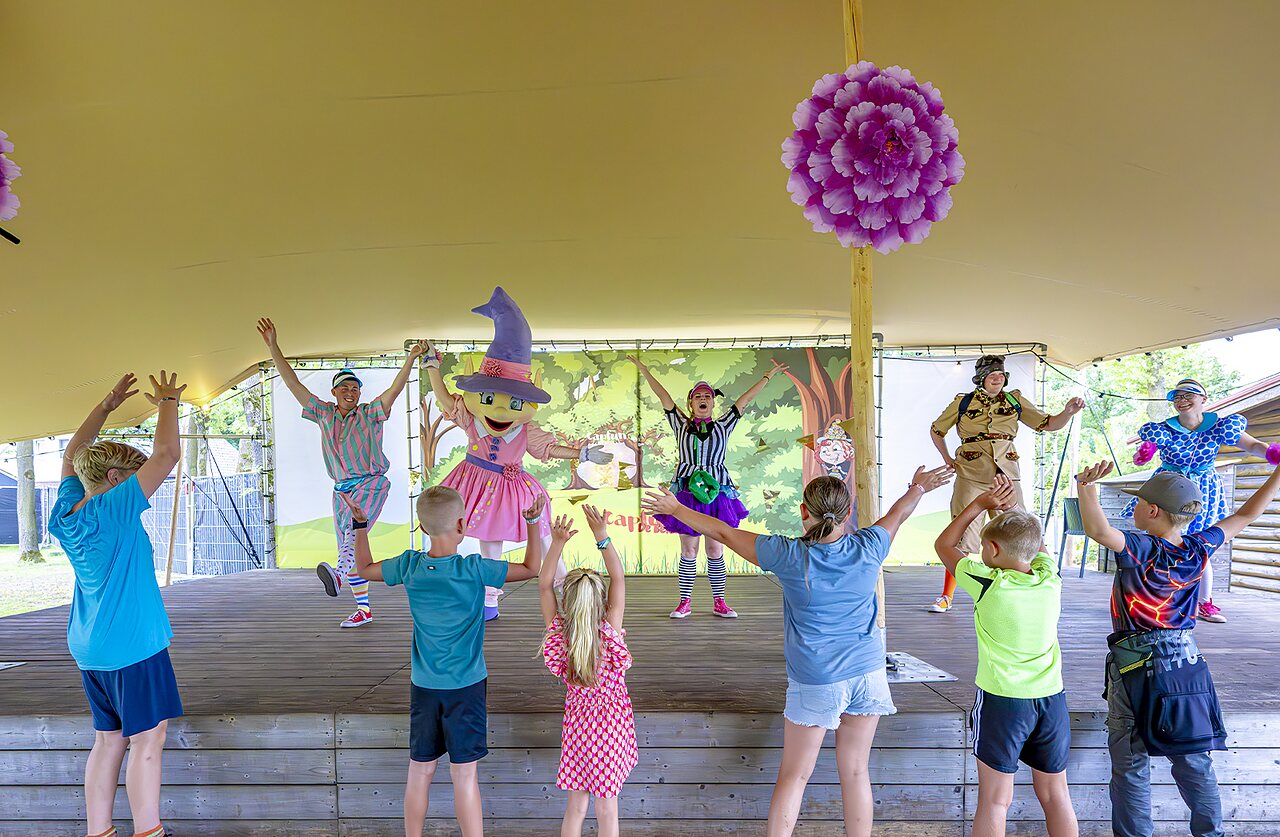 Children enjoying animation show with mascots on stage, CAPFUN De Belten campsite Rheeze.